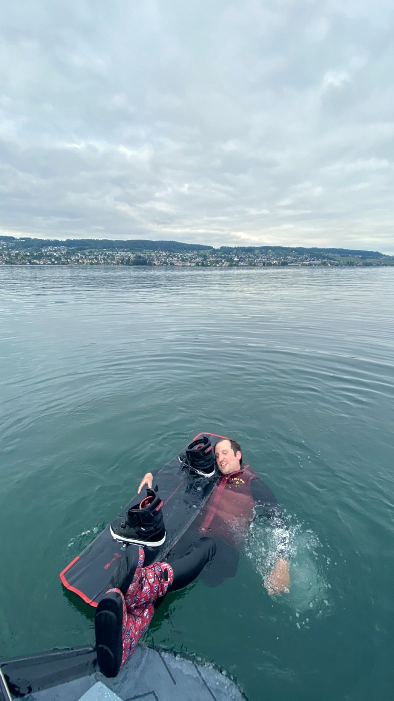 Rider floating on his board in the lake, smiling